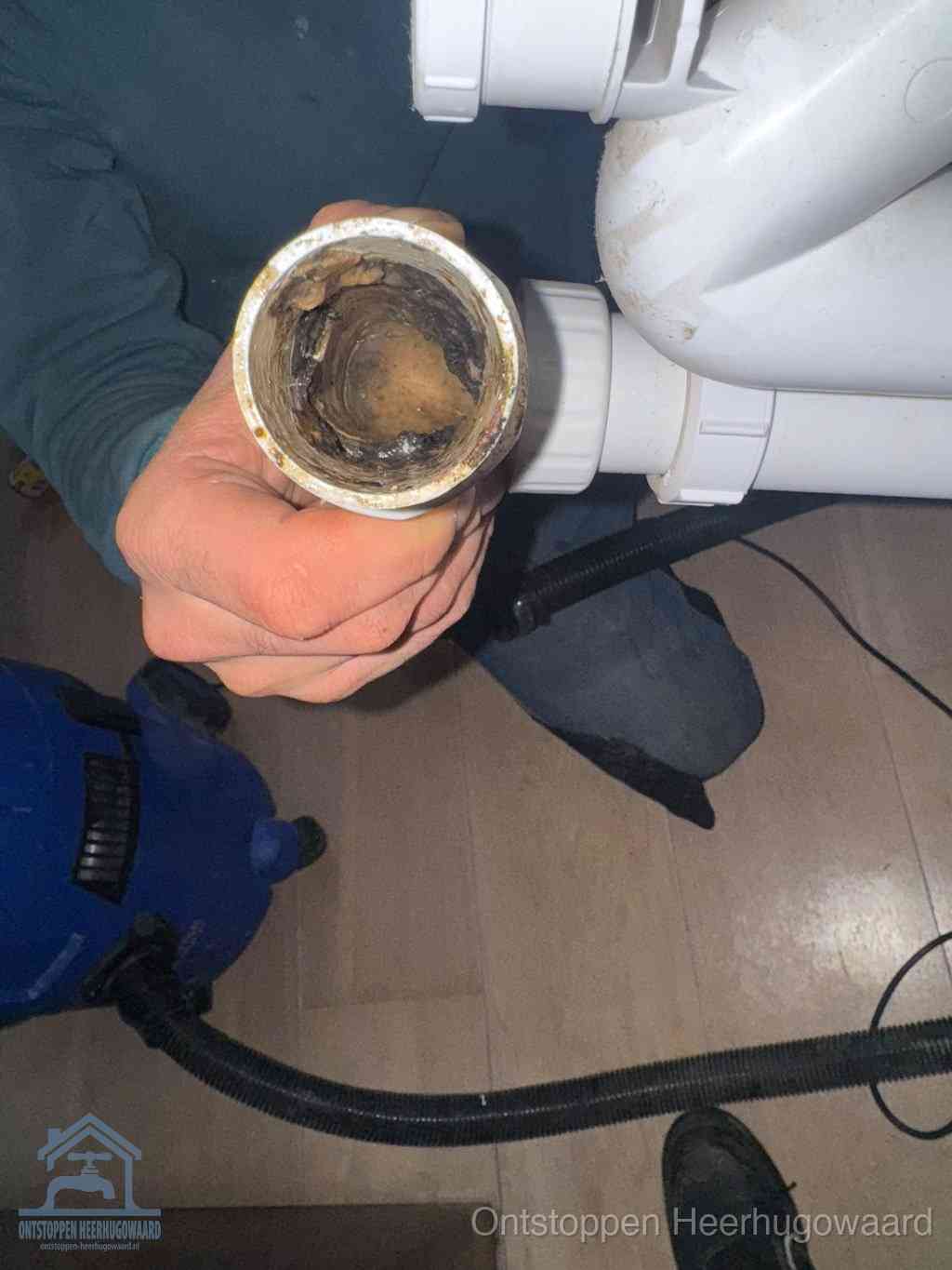 Een losgekoppeld afvoerbuisstuk dat van binnen volledig is dichtgeslibd, het gevolg van een verstopping te lang laten zitten in Heerhugowaard