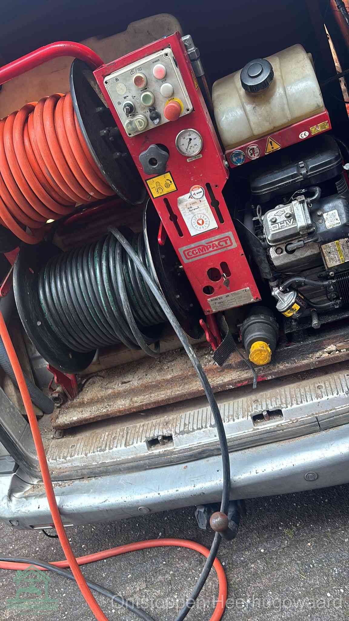 Een rood hogedruk-rioolreinigingstoestel in de laadbak van de bedrijfsbus, apparatuur voor een hardnekkige afvoerverstopping in Heerhugowaard
