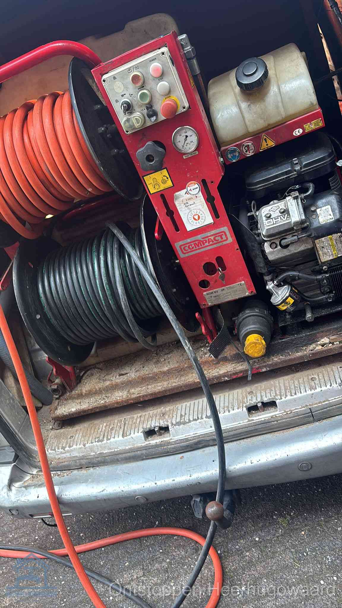 Een rood hogedruk-rioolreinigingstoestel met slangen in de laadbak van de bedrijfsbus, apparatuur voor een hardnekkige wc-verstopping in Heerhugowaard