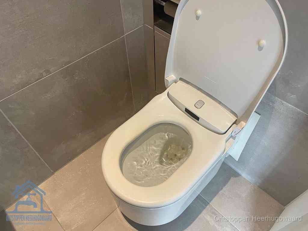 Een toiletpot vol troebel water met drijvend papier en restanten, de meest voorkomende oorzaak van een verstopte wc in Heerhugowaard